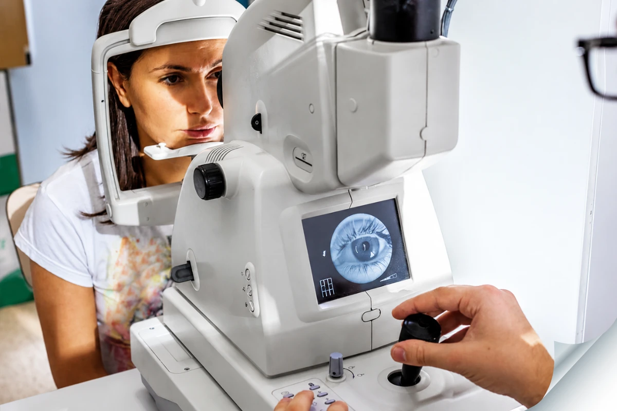 Patient undergoing retinal eye examination using diagnostic imaging equipment